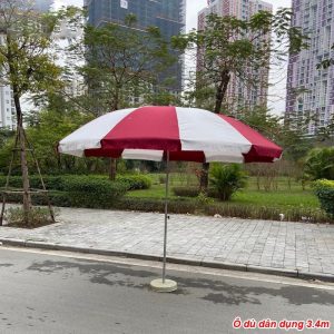 Ô che nắng trụ giữa với tán đỏ trắng và chân đế tròn