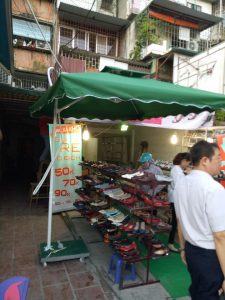 Bộ dù tán xanh có trụ bên và đế bánh xe đặt tại khu bán hàng ngoài trời